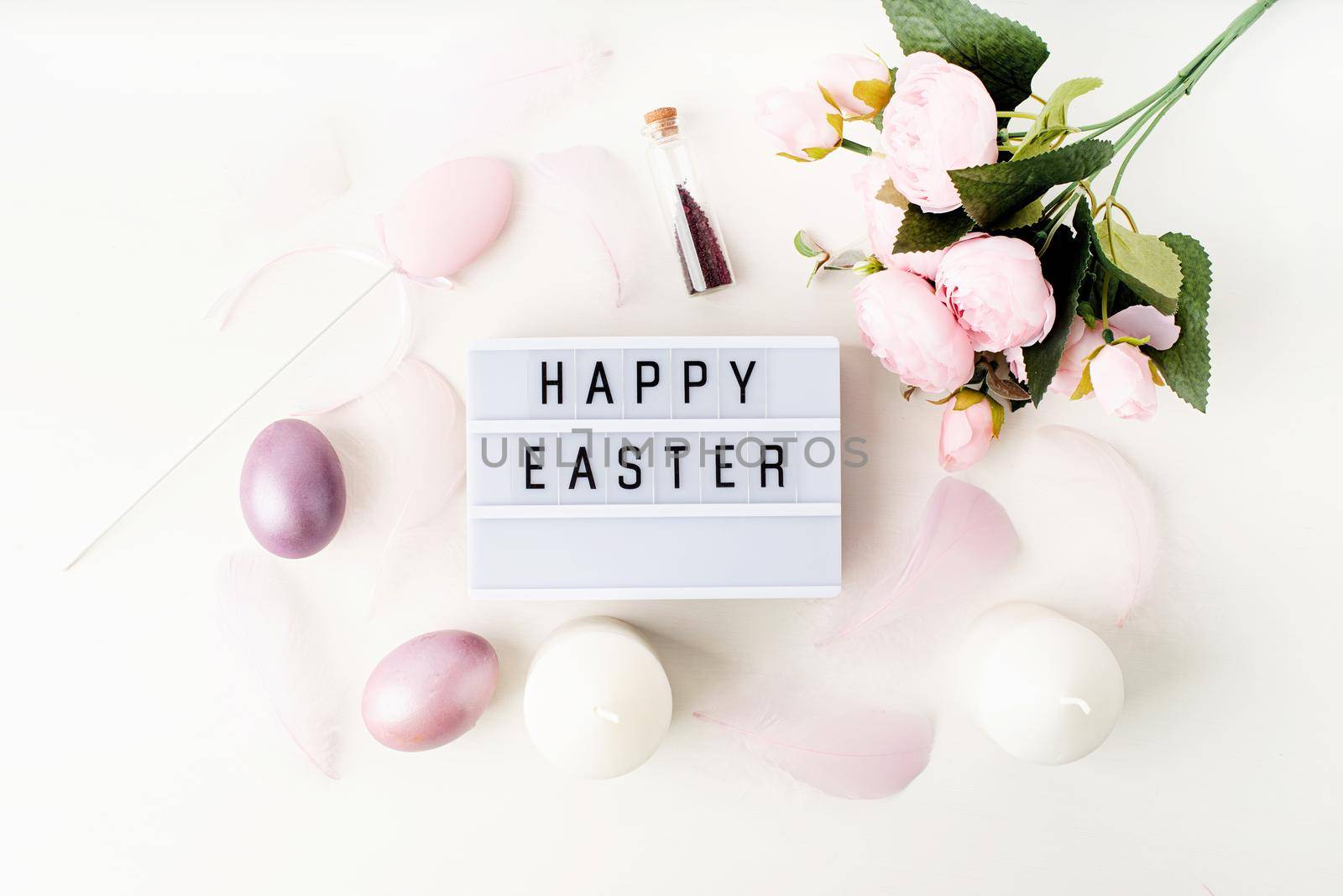 Easter holiday. Top view Happy Easter light box decorated with pastel colored eggs and feathers