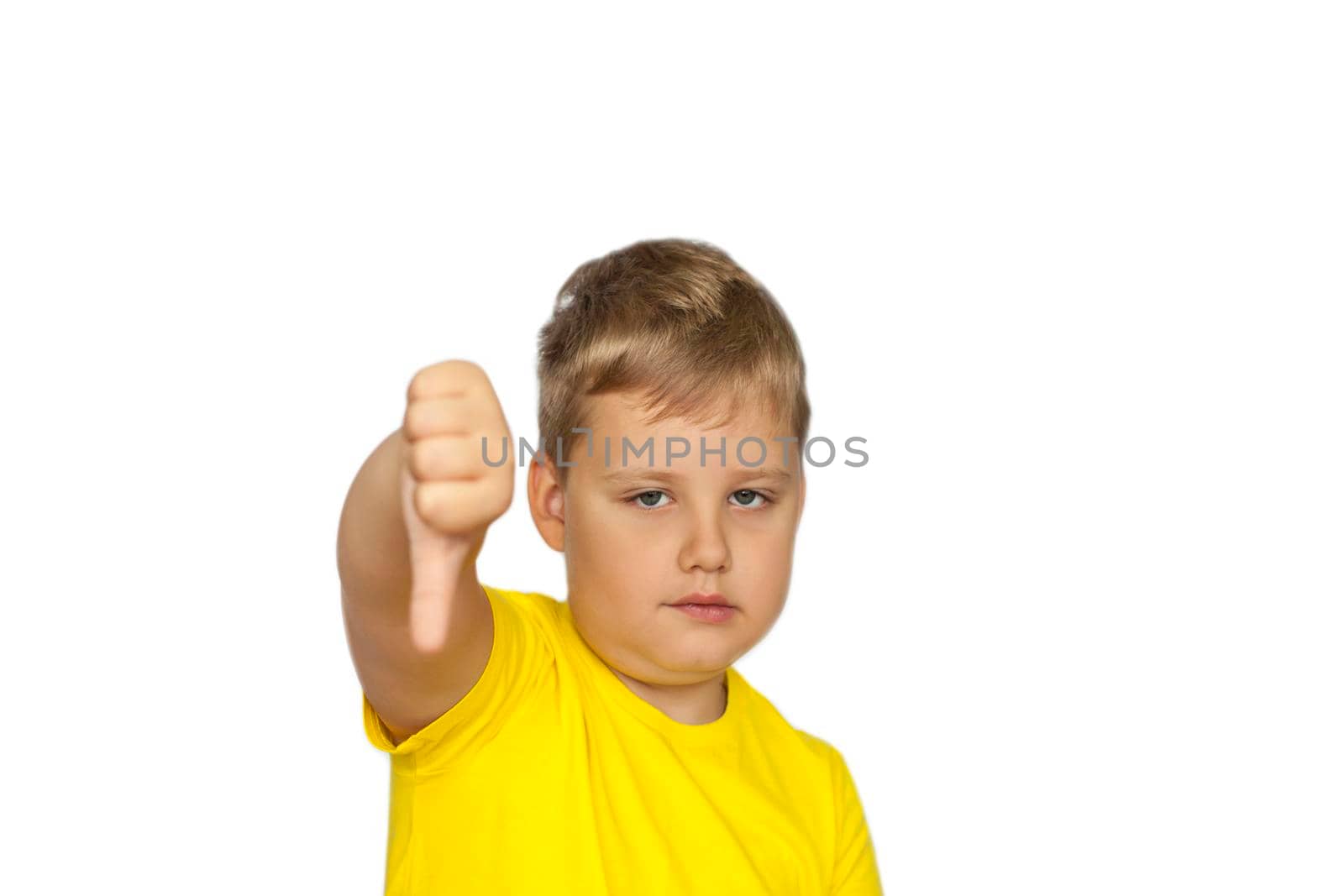 A boy in a yellow T-shirt on a white background points at a negative rating. Dislike. The concept of a banner with information. Space for the text. Concepts