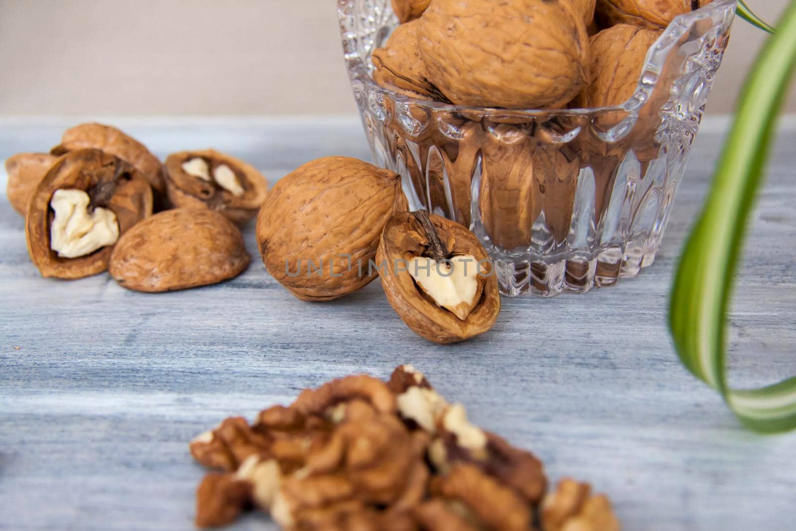 Walnuts on a painted background. Crystal bowl with nuts. Useful products. Walnuts.