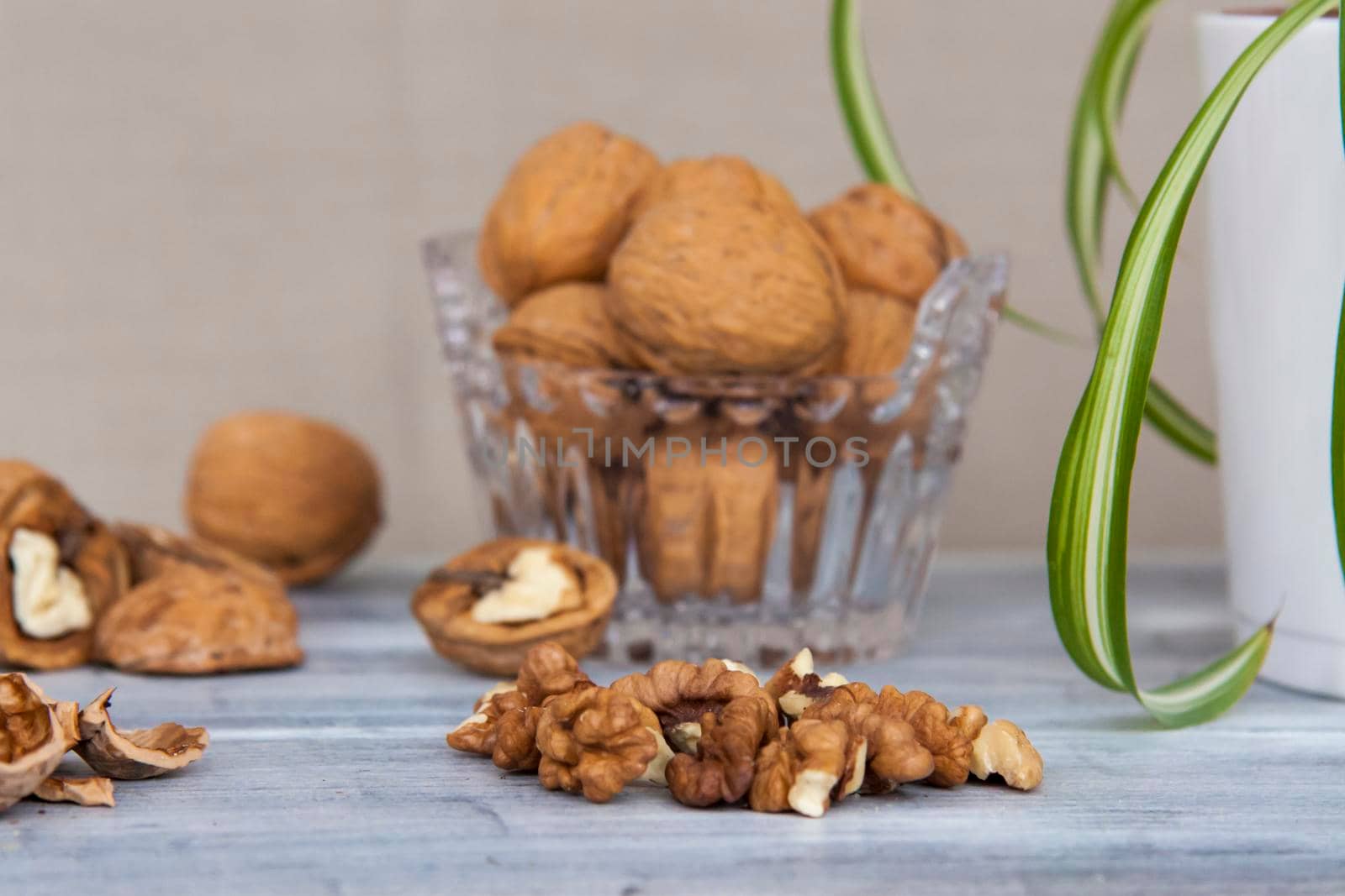 Walnuts on a painted background. Crystal bowl with nuts. Useful products. Walnuts.