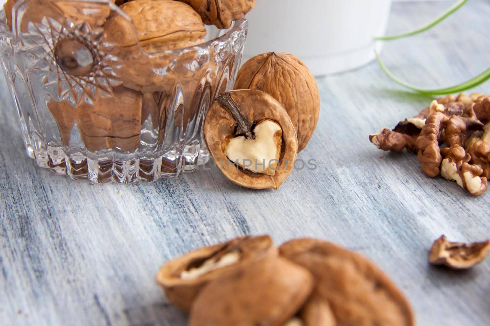 Walnuts on a painted background. Crystal bowl with nuts. Useful products. Walnuts.