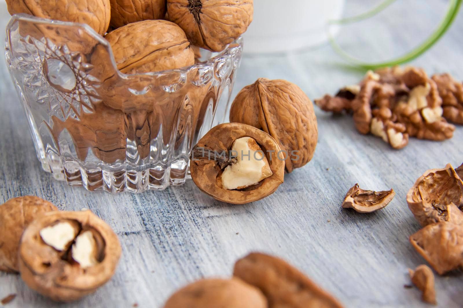 Walnuts on a painted background. Crystal bowl with nuts. Useful products. Walnuts.