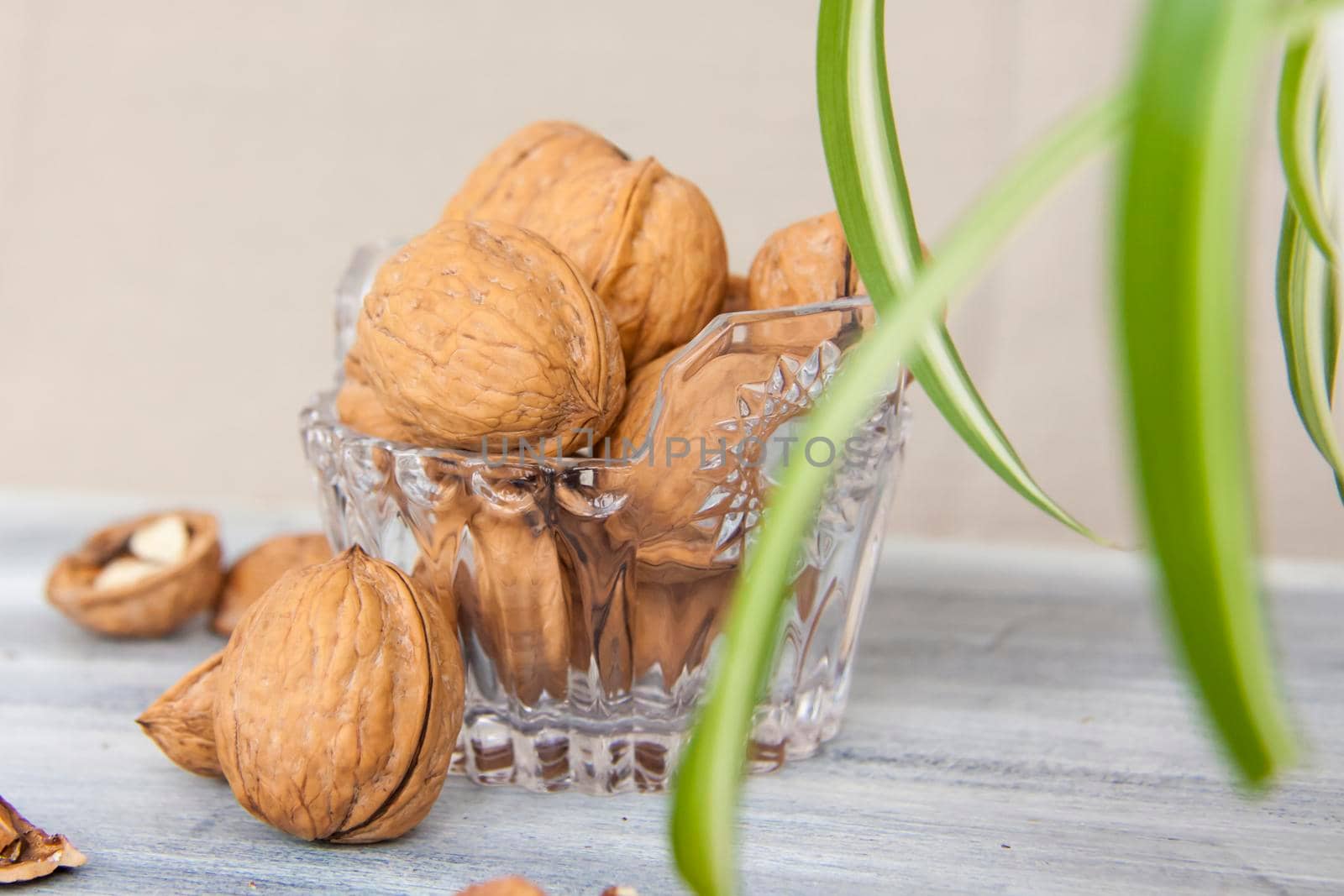 Walnuts on a painted background. Crystal bowl with nuts. Useful products. Walnuts