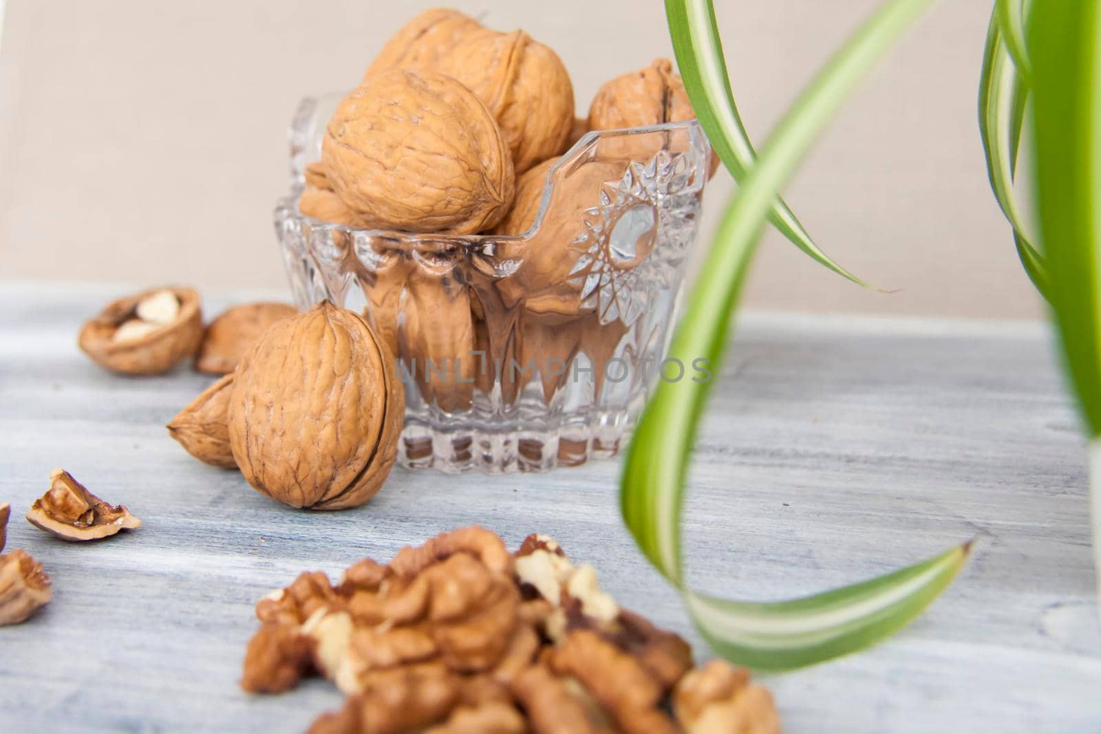 Walnuts on a painted background. Crystal bowl with nuts. Useful products. Walnuts.