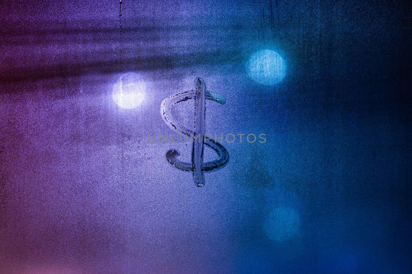Dollar currency sign handwritten on fogged window. Dollar symbol on wet night window glass surface.