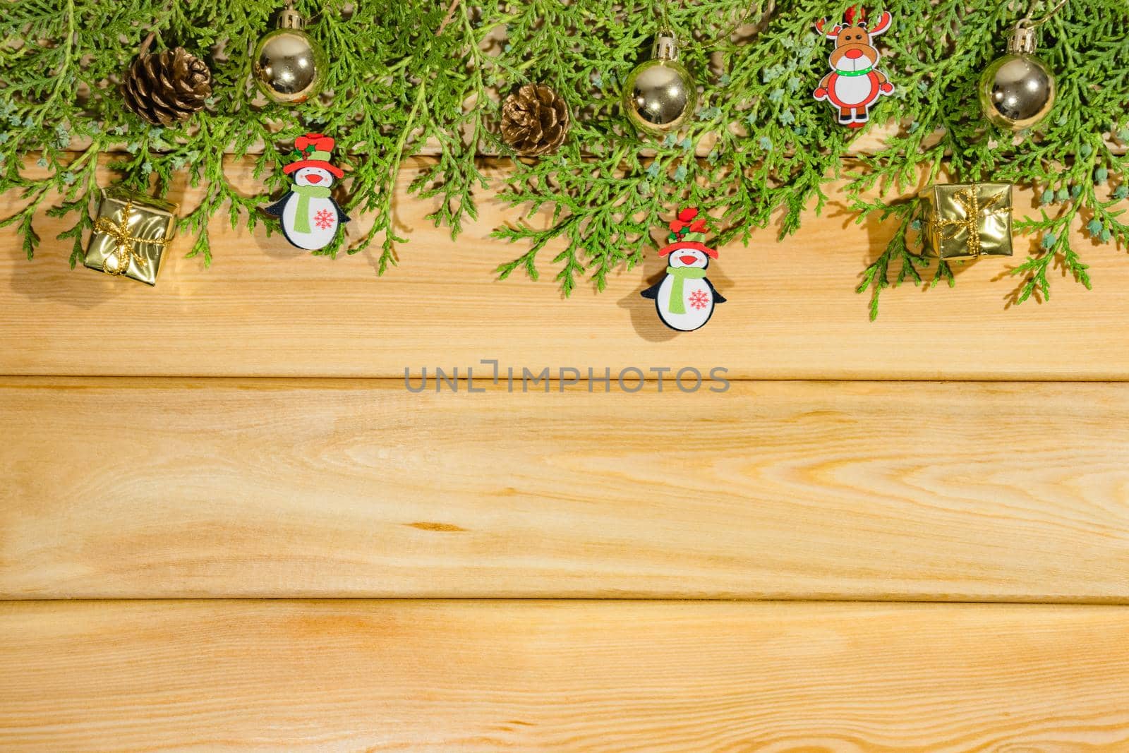 coniferous branches with Christmas toys on a wooden background top view by roman112007