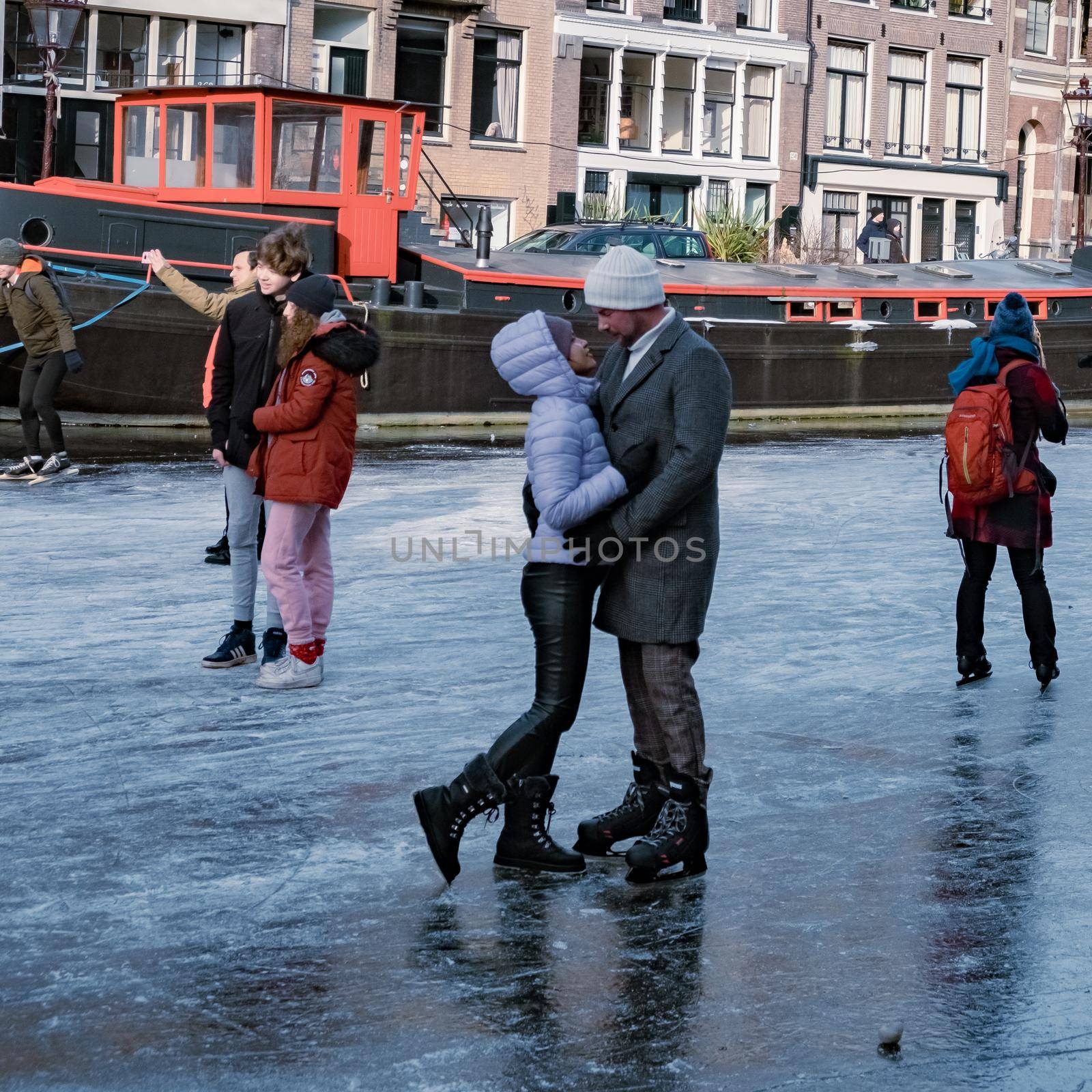 Ice skating on the canals in Amsterdam the Netherlands in winter, frozen canals in Amsterdam during winter by fokkebok