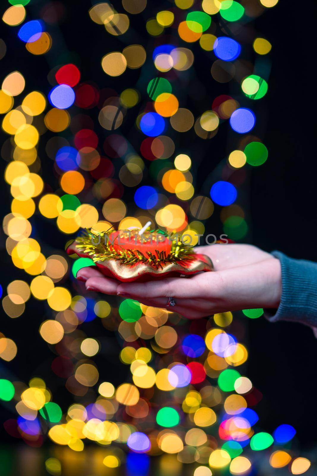 Woman's hands hold christmas decoration. Christmas and New Year holidays background, winter season with Christmas ornaments and blurred lights