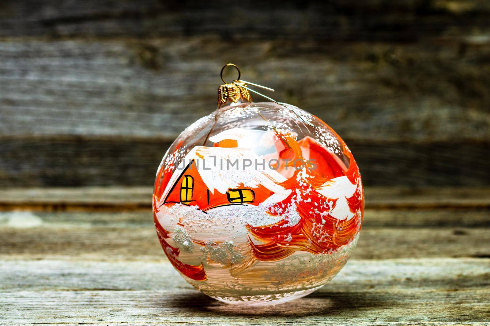 Close up of decorated glass Christmas ball bauble on wooden background,