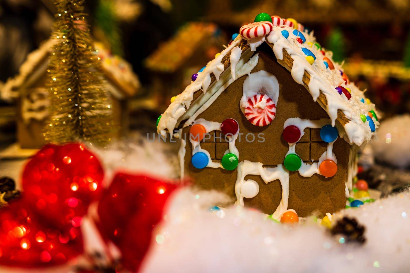 Colorful gingerbread house isolated on blurred background with Christmas decoration. by vladispas