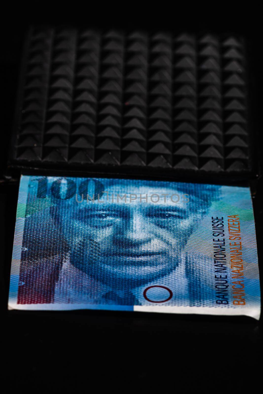  100 swiss franc banknote in a black wallet isolated. by vladispas
