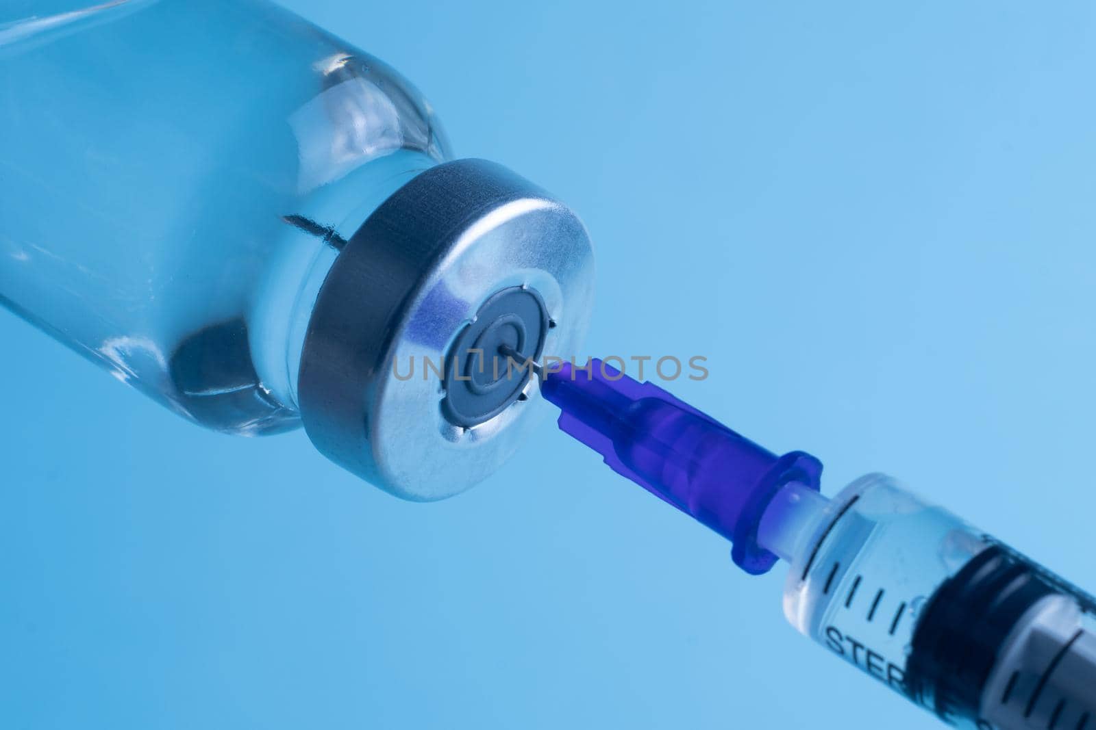 Close-up of filling a syringe with vaccine. A syringe with a needle draws the medicine. by Yurii73