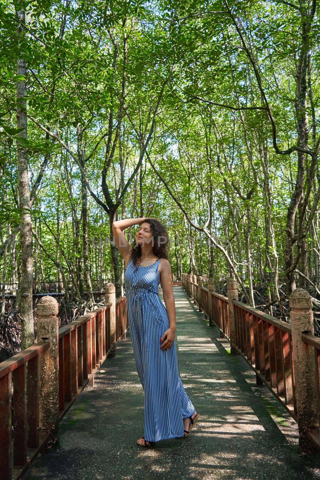 Beautiful girl walking through the mangrove forest in Asia.