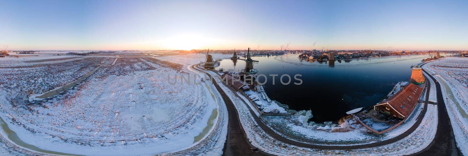 panoramic view over the Zaanse Schans windmill village snow covered during winter, Zaanse Schans wind mills historical wooden mills in the Netherlands by fokkebok
