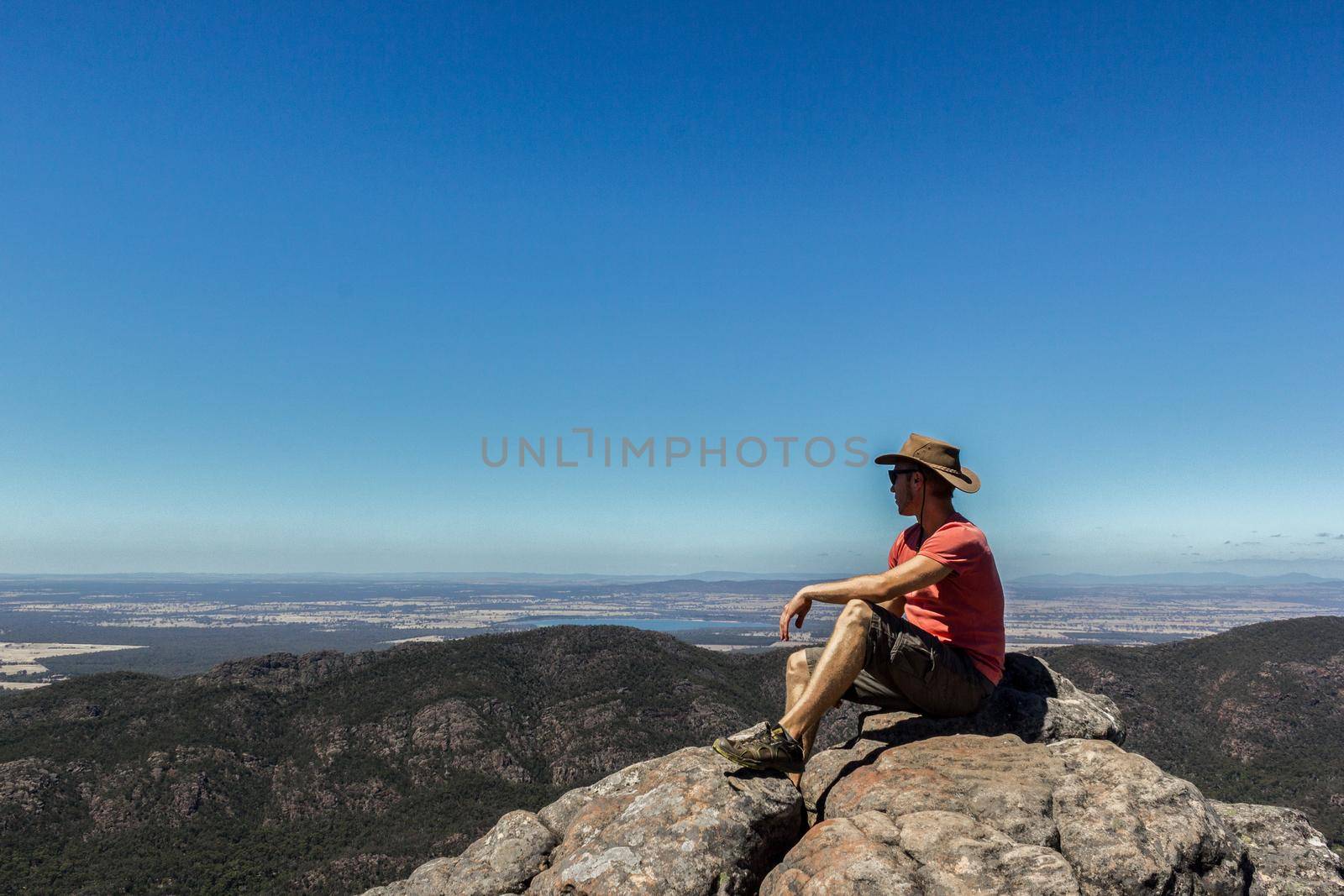young man sitting on a rock at the Boroka Lookout, Grampians National Park, Australia