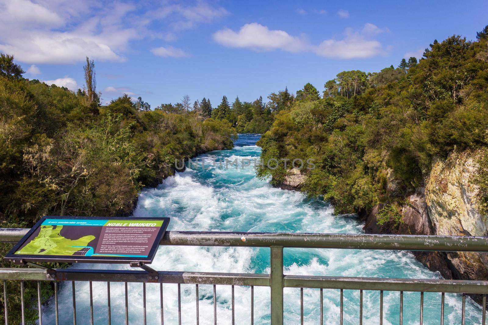 Powerful Huka Falls with a sign with information about the falls, on the Waikato River near Taupo North Island New Zealand by bettercallcurry