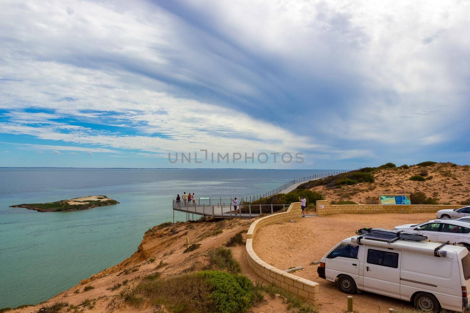 a Group of tourists at a Lookout platform in Monkey Mia, Western Australia. Caucasian girl enjoying cliffs of Indian Ocean coastline. by bettercallcurry