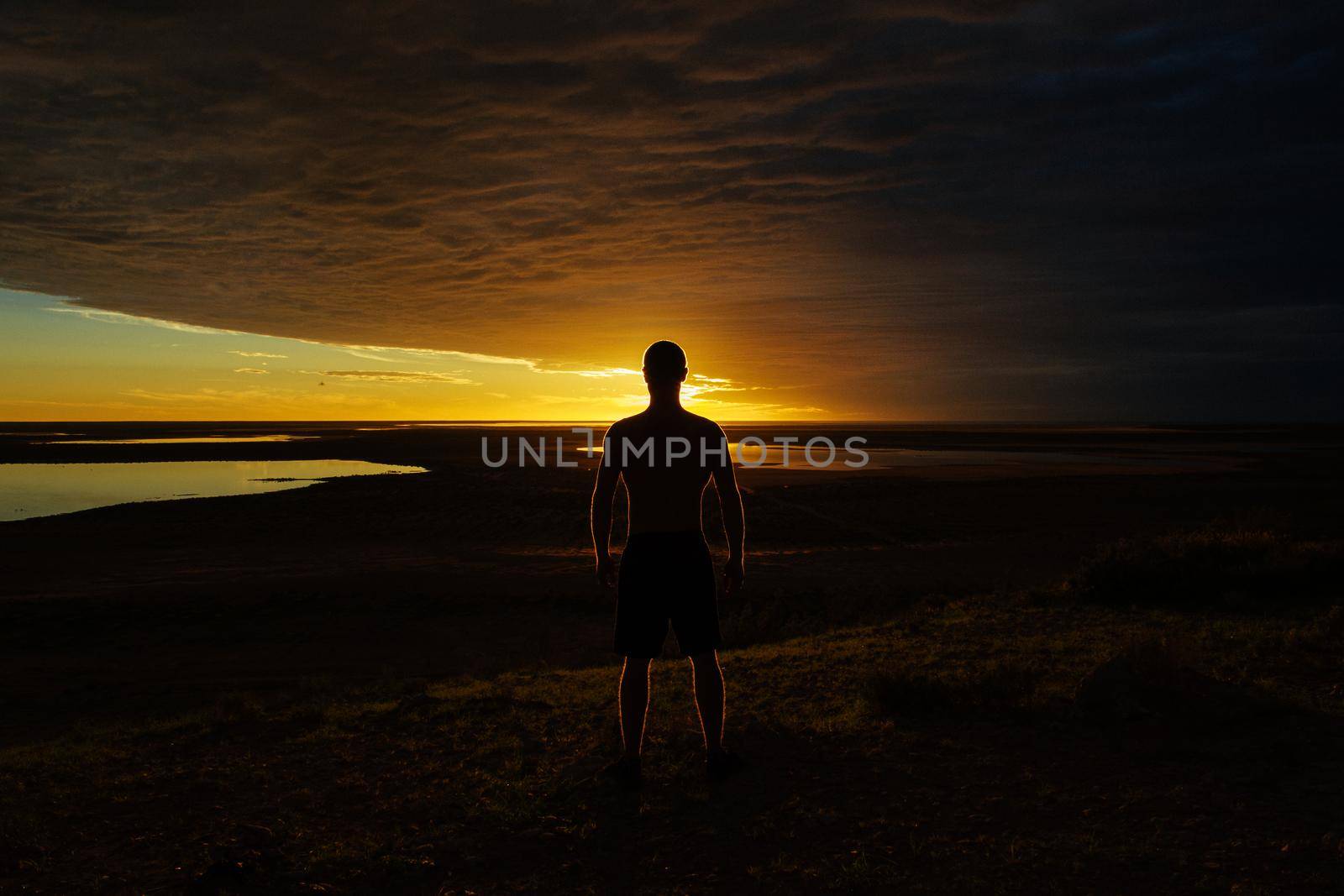 silhouette of a jung man enjoying beautiful sunset in the australian outback with 3 lakes, Gladstone scenic lookout, Australia by bettercallcurry