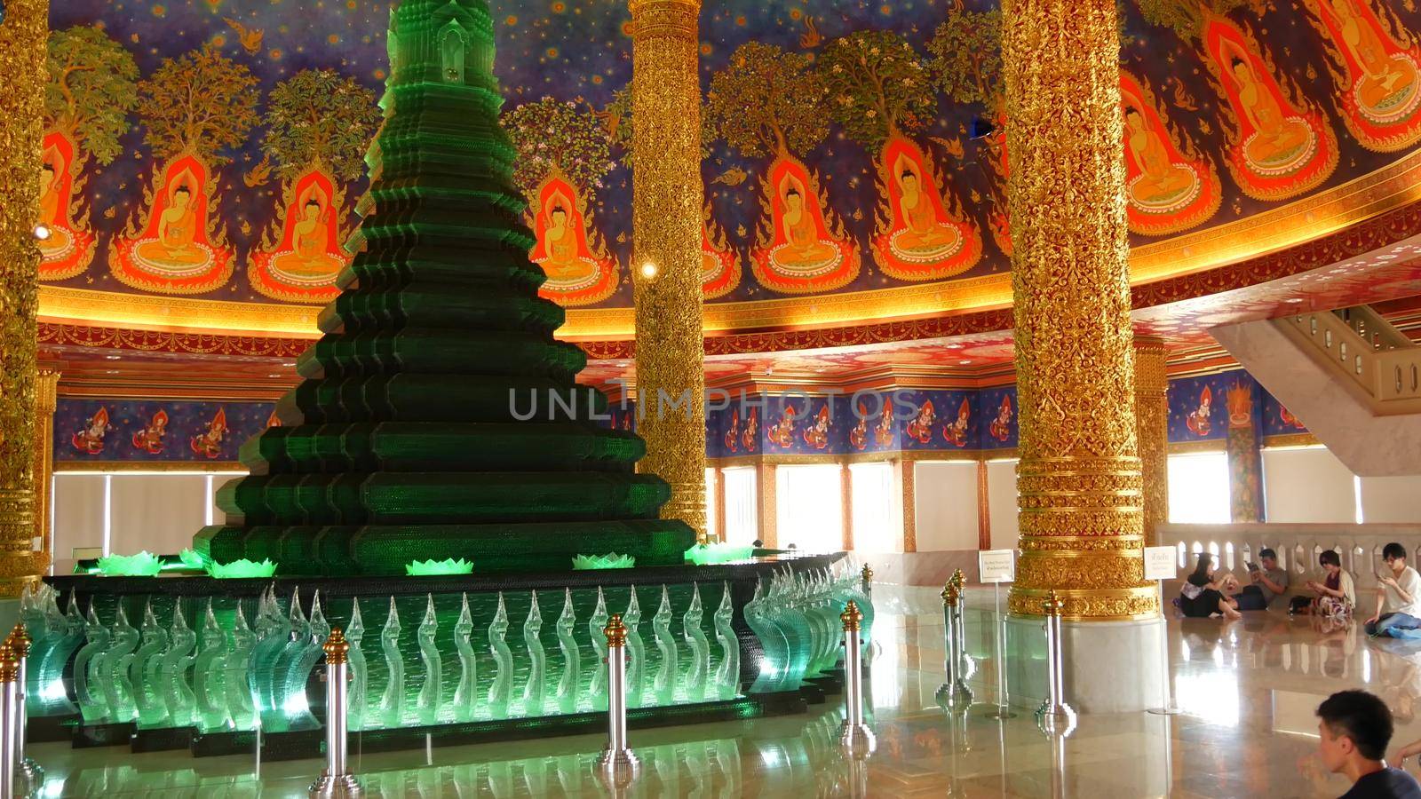 BANGKOK, THAILAND - 13 JULY, 2019: Wat Pak Nam or Paknam traditional oriental buddhist temple interior. Emerald glass stupa under vivid colorful ceiling, circular dome roof colored with acid colors.