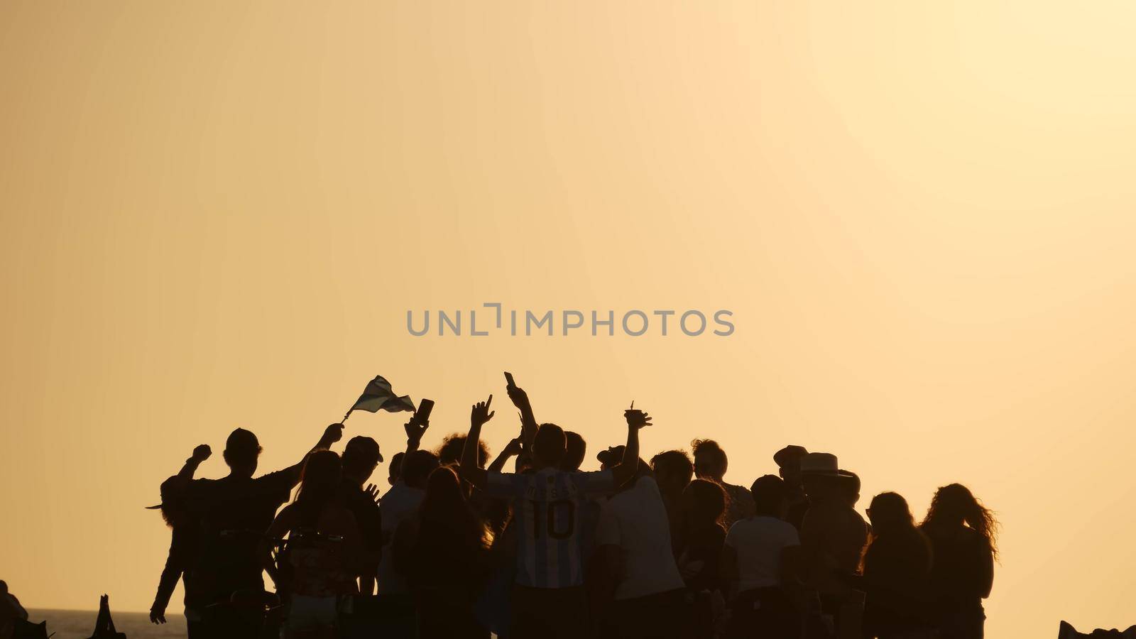 LOS ANGELES CA USA - 16 NOV 2019: California, happy young multiracial friends having fun and hanging out. Group of multiethnic people dancing on party in sunset light. Venice beach summertime leisure by DogoraSun