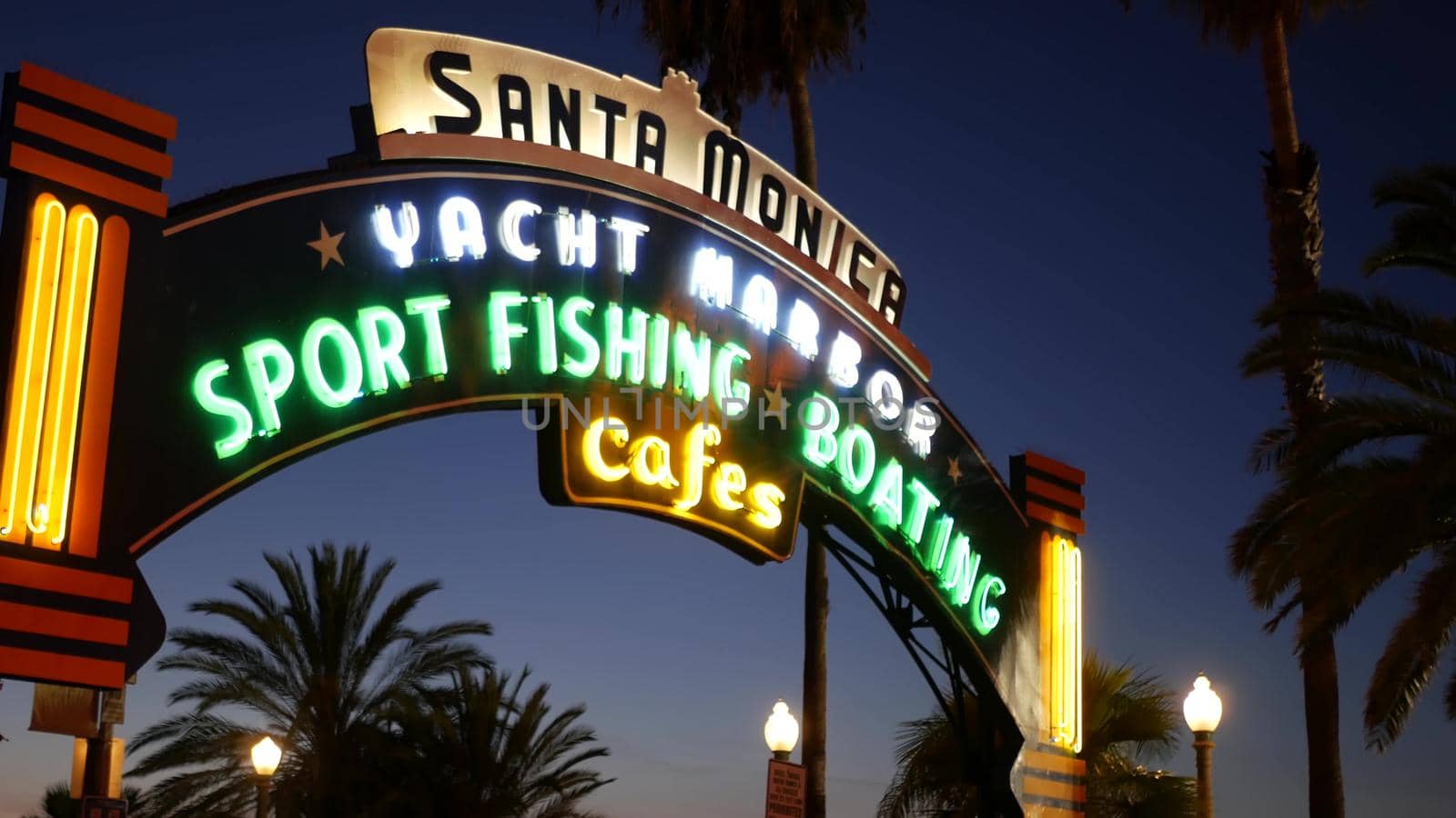 SANTA MONICA, LOS ANGELES CA USA - 19 DEC 2019: Summertime iconic vintage symbol. Classic illuminated retro sign on pier. California summertime aesthetic. Glowing lettering on old-fashioned signboard by DogoraSun