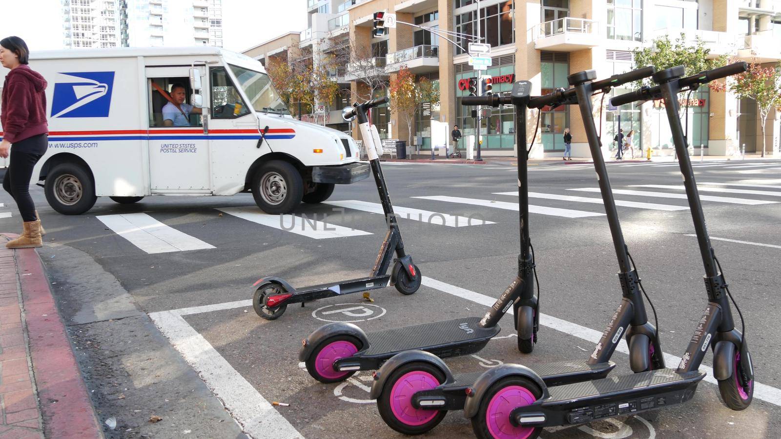 SAN DIEGO, CALIFORNIA USA - 4 JAN 2020: Row of ride sharing electric scooters parked on street in Gaslamp Quarter. Rental dockless public bikes, eco transport in city. Rent kick cycle with mobile app.