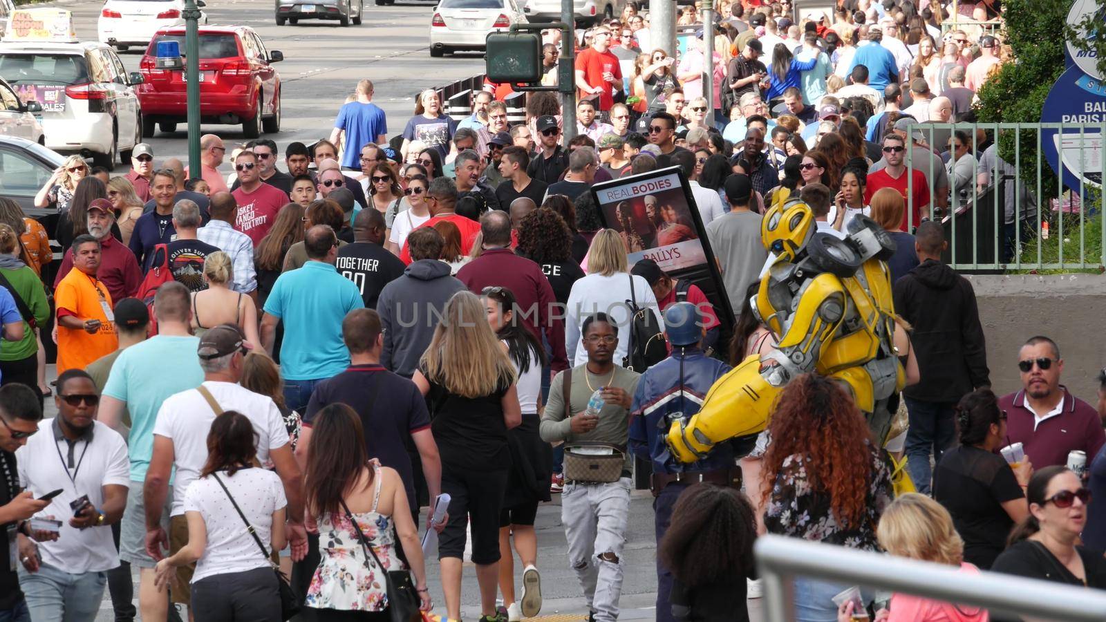 LAS VEGAS, NEVADA USA - 7 MAR 2020: People on pedestrian walkway. Multicultural men and women walking on city promenade. Crowd of citizens on sidewalk. Diversity of multiracial faces in metropolis by DogoraSun