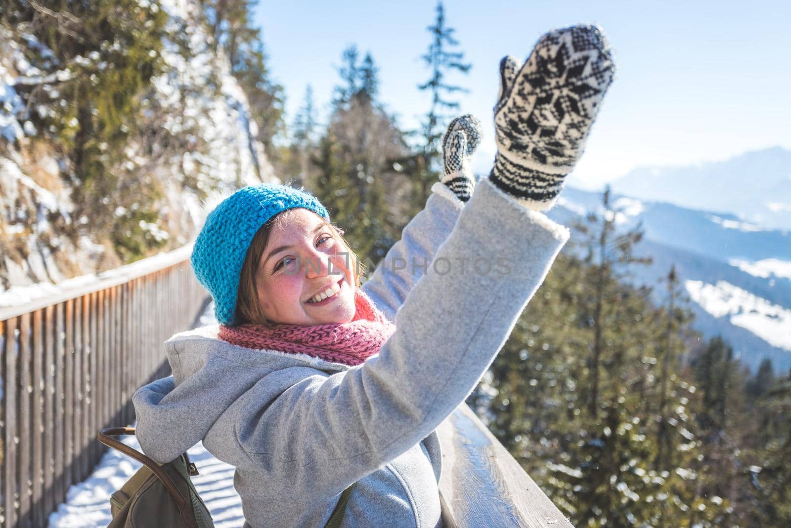 Happy young woman is raising her hands on the mountain, enjoying the view over Salzburg. Winter time on Gaisberg, Salzburg, Austria by Daxenbichler