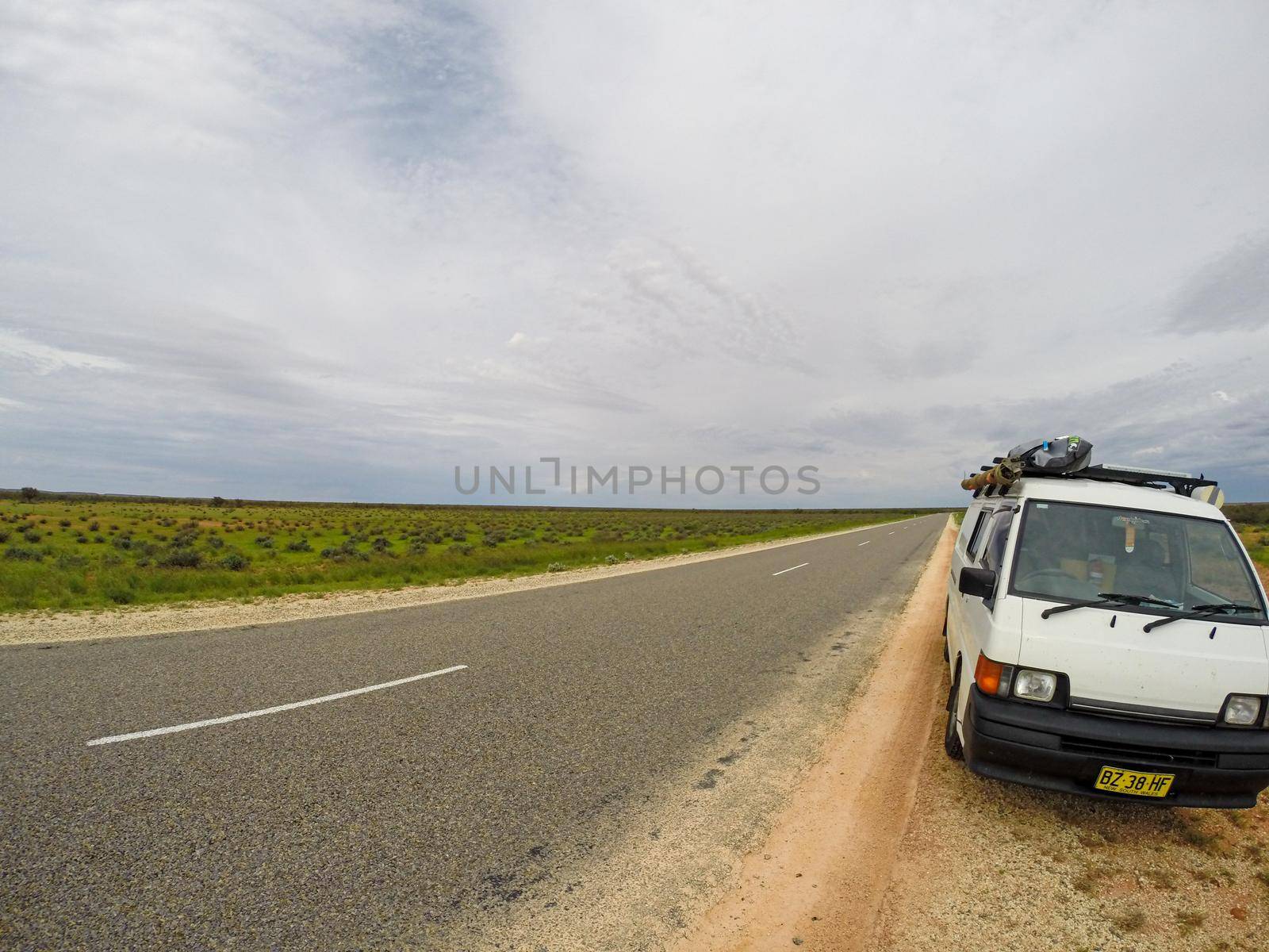van parking on a straight road with dessert on the Burkett Road south of Exmouth of Western Australia, Australia by bettercallcurry