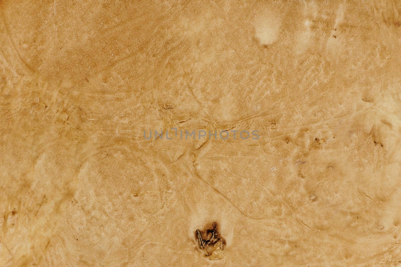 Brown vintage paper with a damaged surface and a burnt spot at the bottom.Texture or background