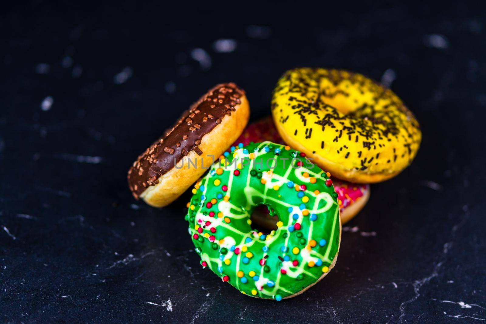 Glazed donuts with sprinkles isolated. Close up of colorful donuts.
