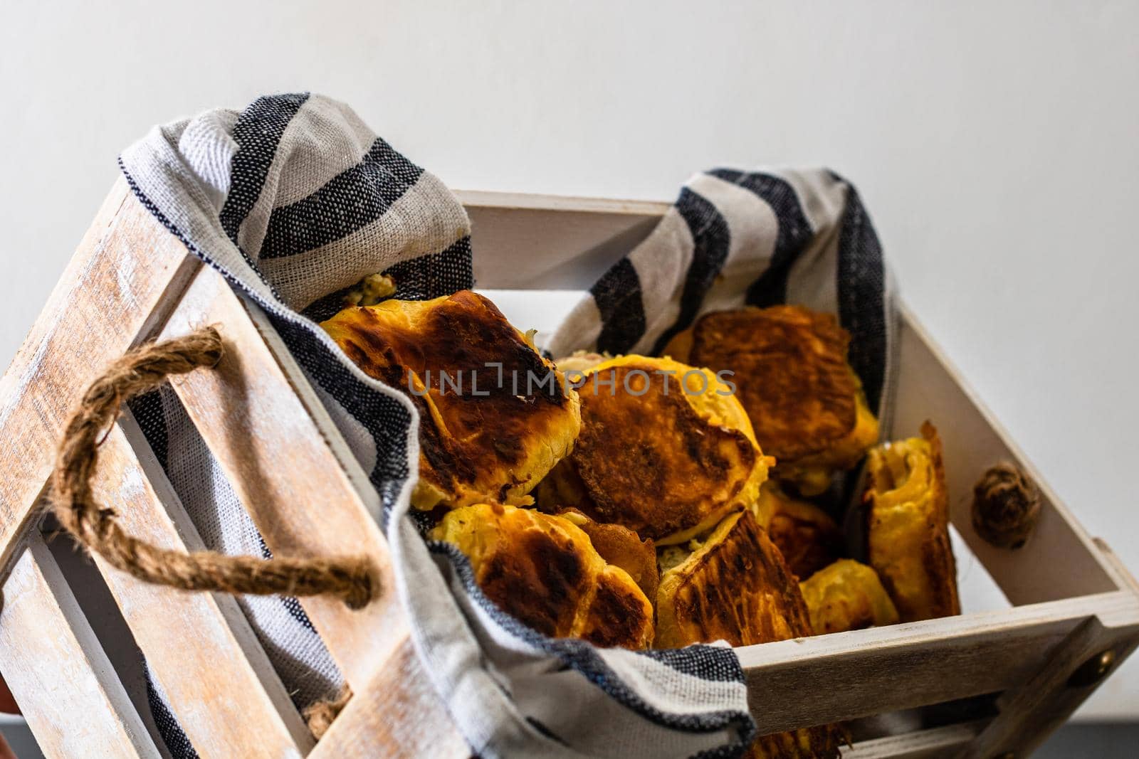 Freshly baked homemade ham and cheese puff pastry in a rustic crate.