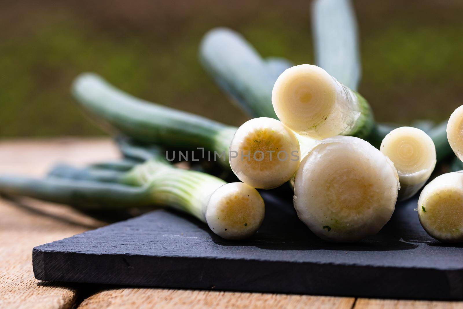 Close up of details of fresh green onions (scallion) on a cutting board isolated.