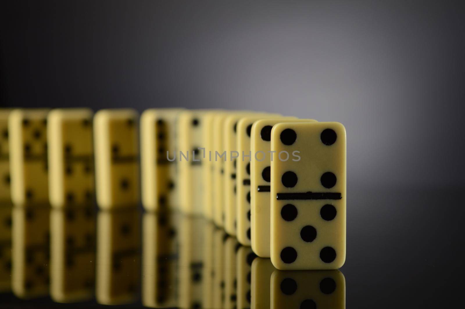 A row of dominoes are lined up before the fall.