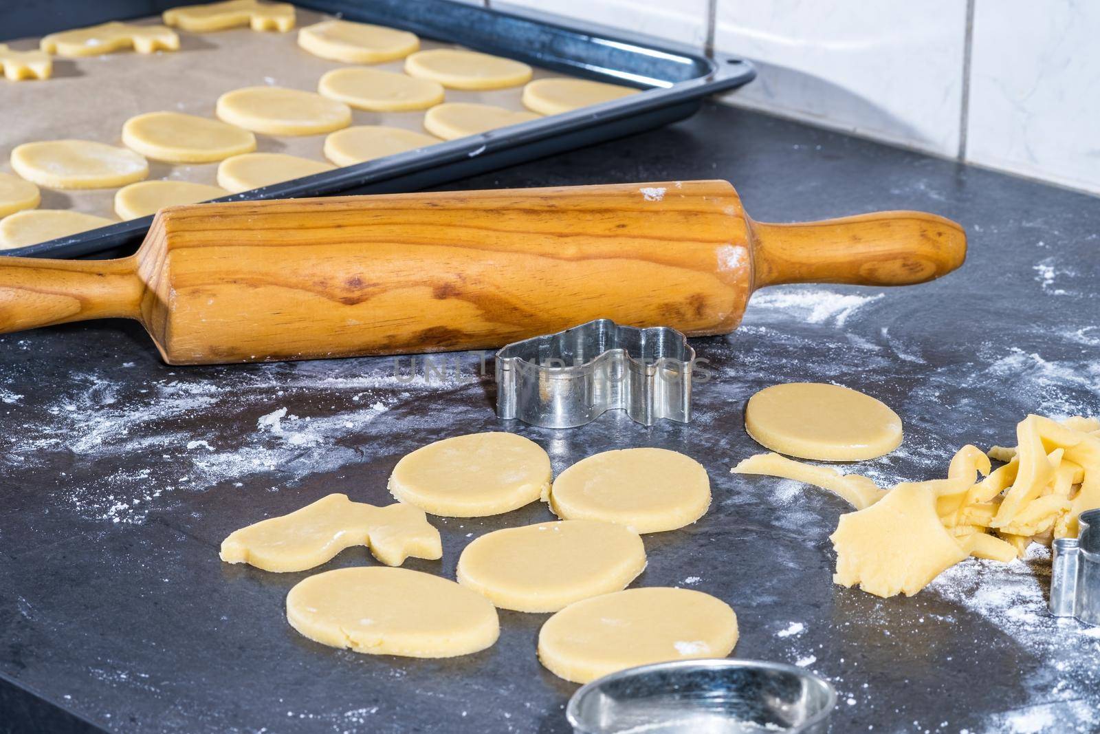 Rolling pin and kitchenware for making easter cookies on dark background.