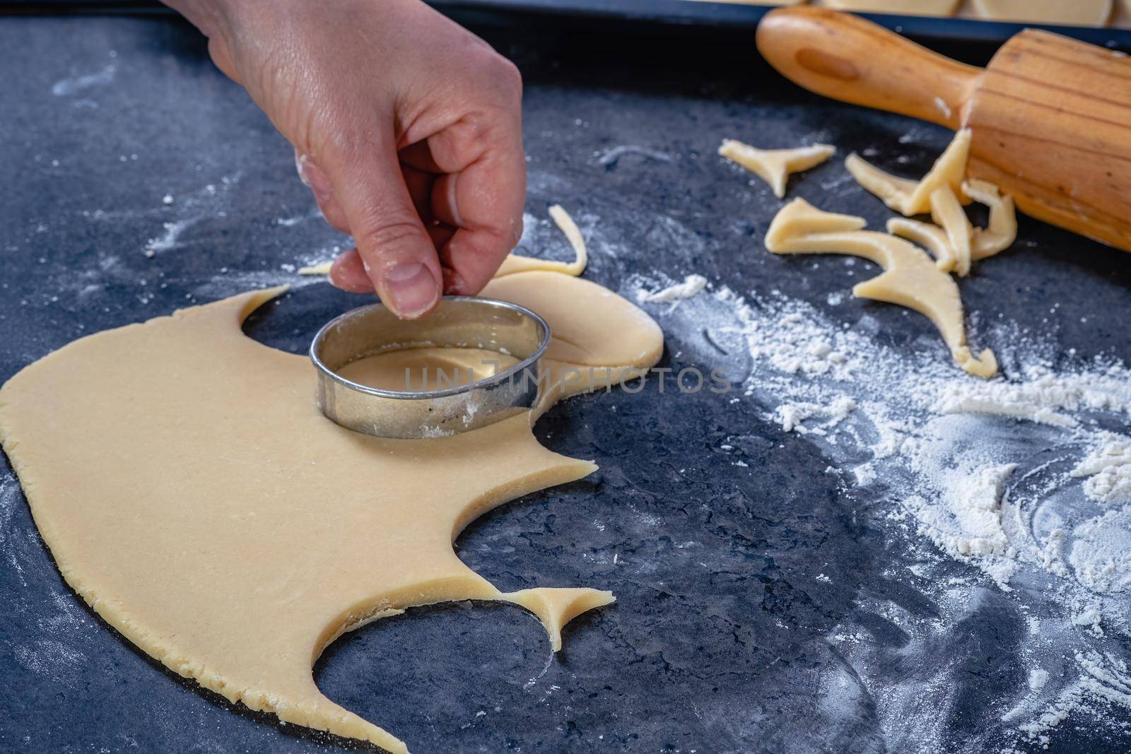 Woman prepares butter cookies at home in the kitchen by Fischeron