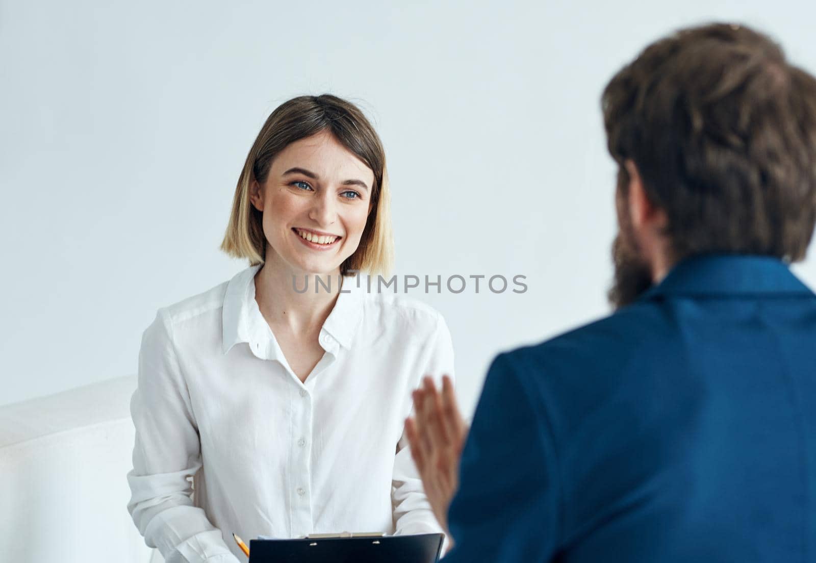 A man in a blue jacket and a woman in a shirt documents light background indoor. High quality photo