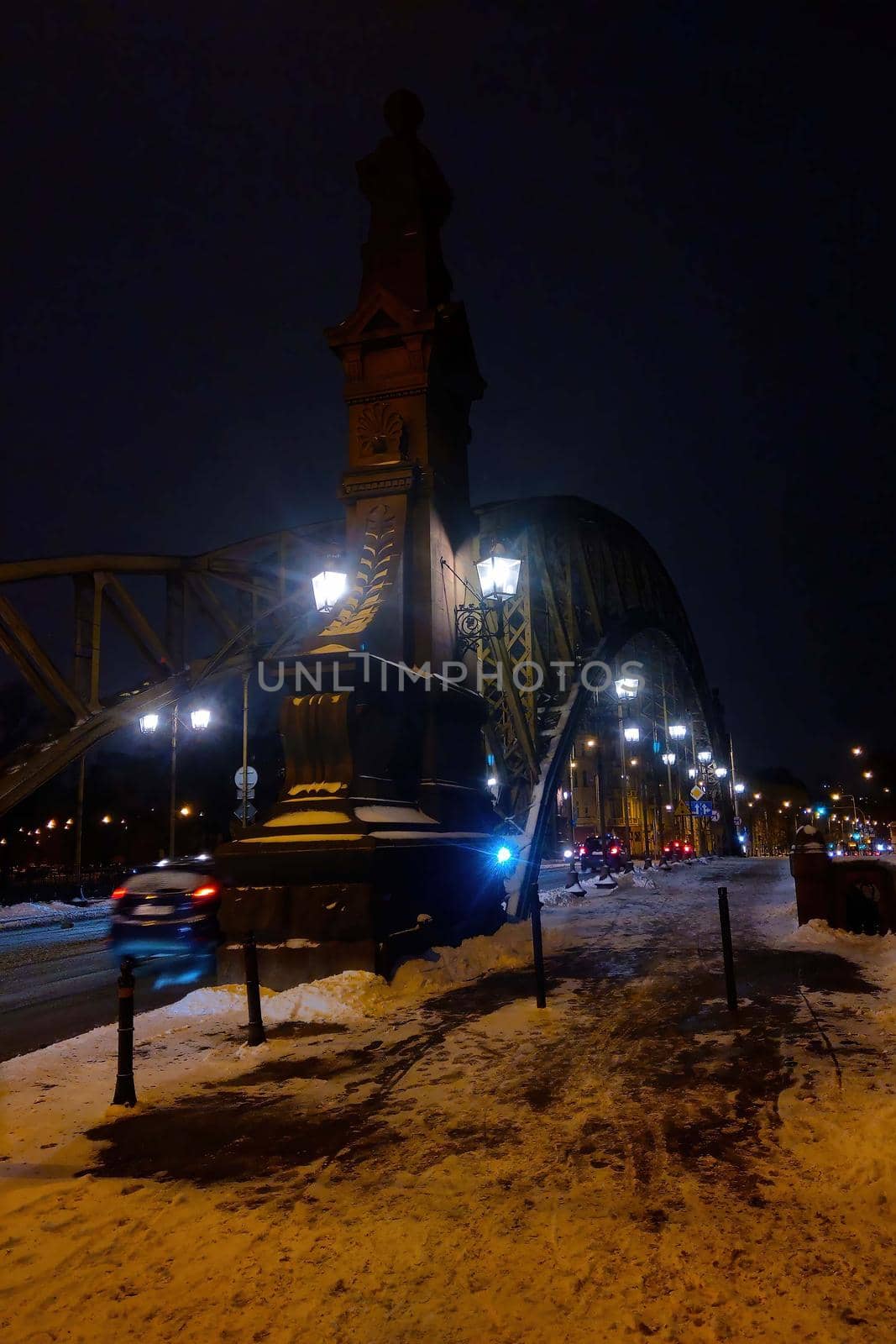 Old iron bridge over the river in the city in the evening