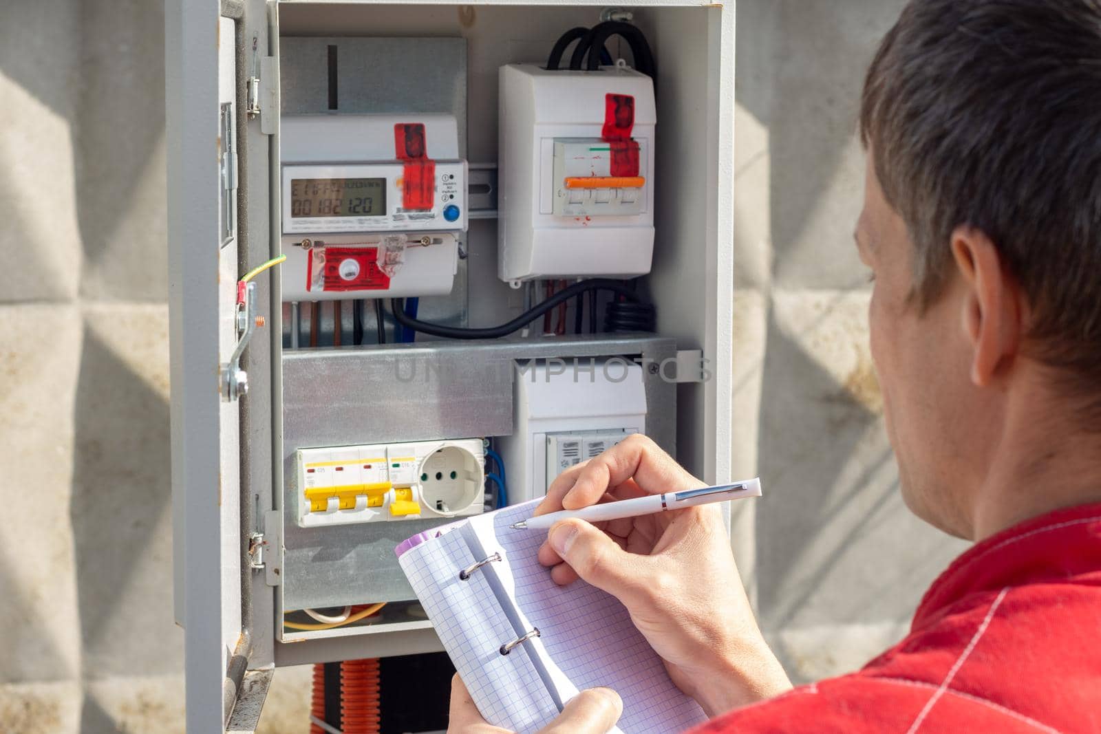 Man taking readings of an electric meter