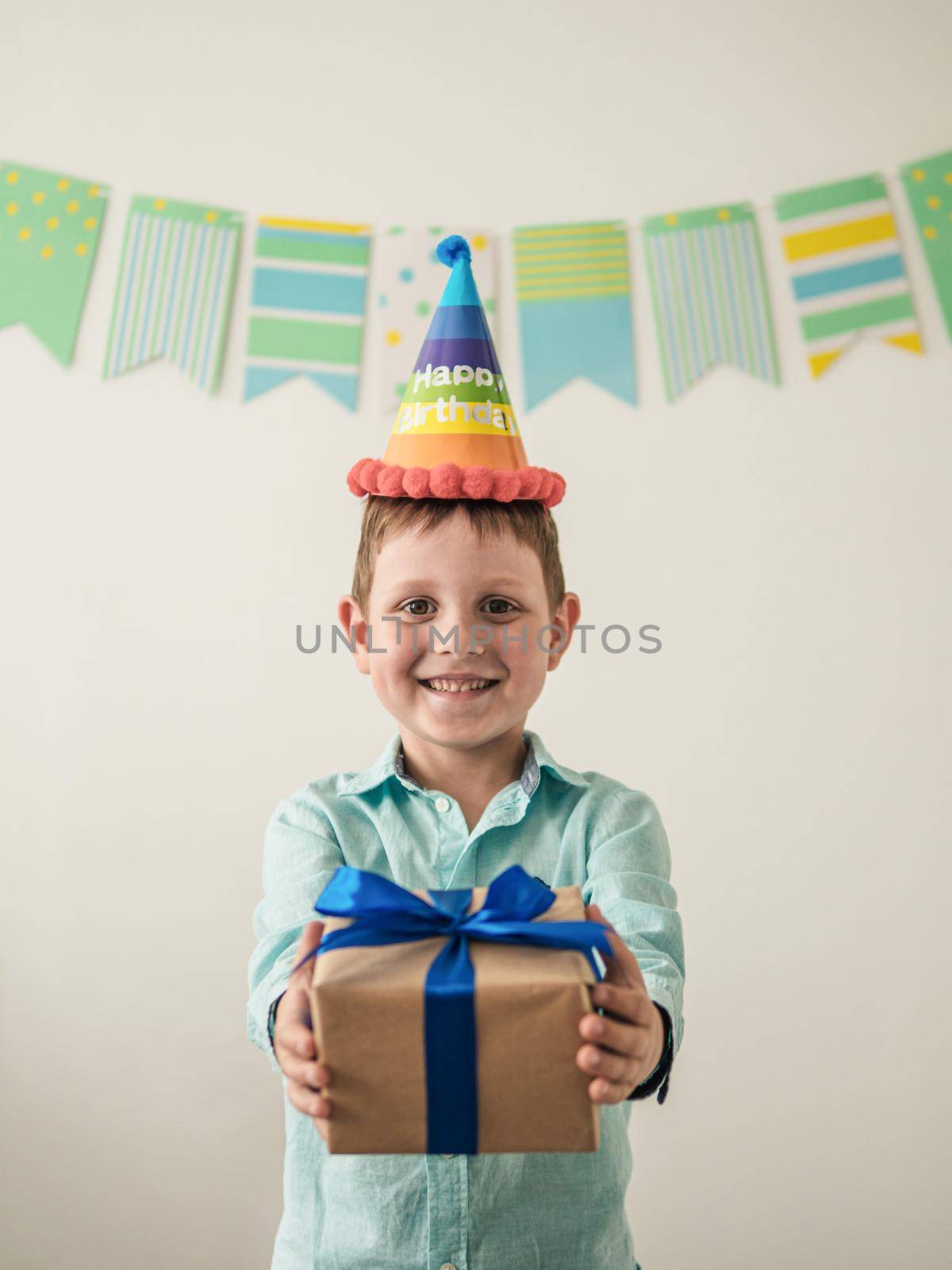 Five year old boy in his birthday hold gift box. Happy little child hold gift box with present and looking at camera