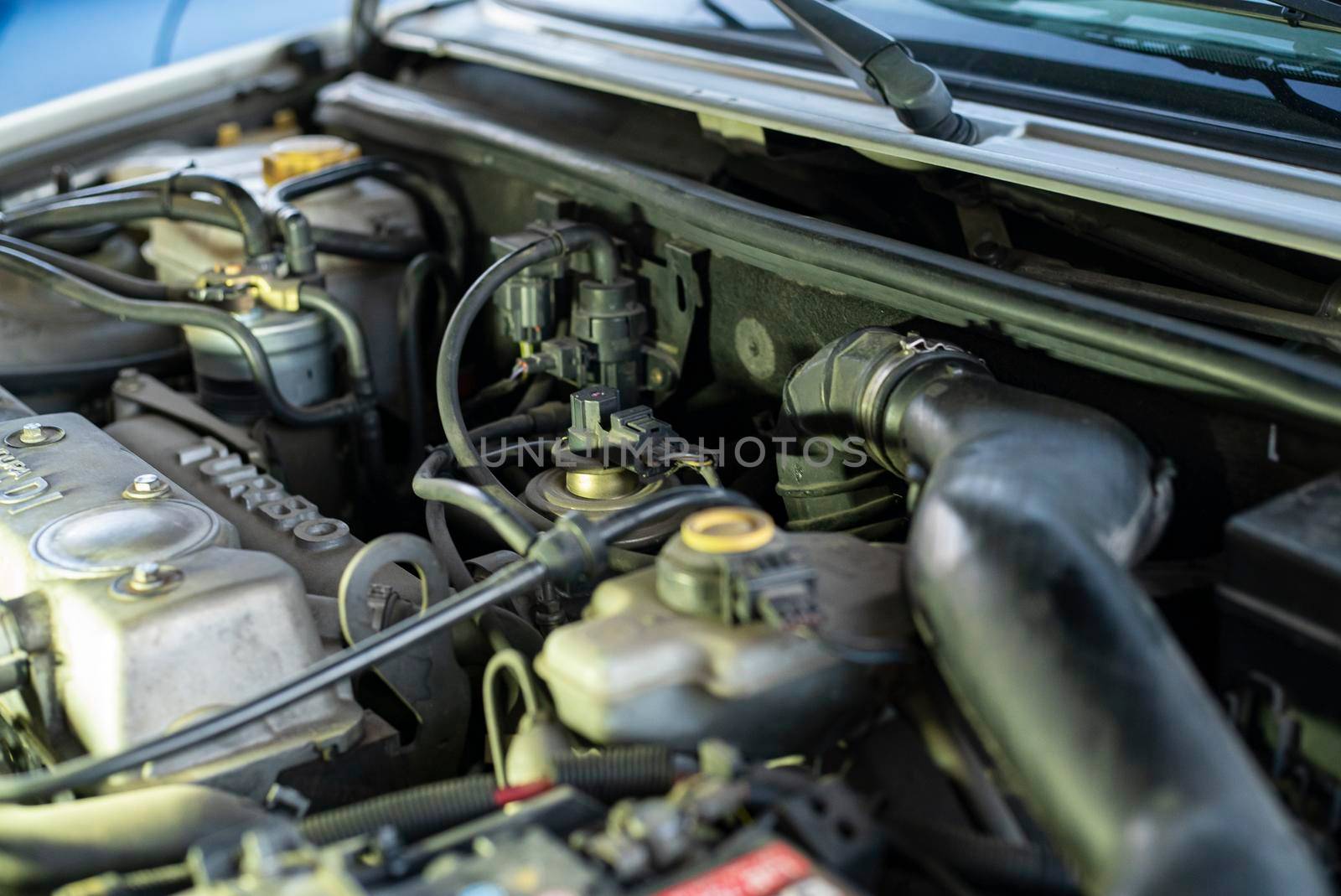 Detail of a used engine with mechanical parts on view inside a car