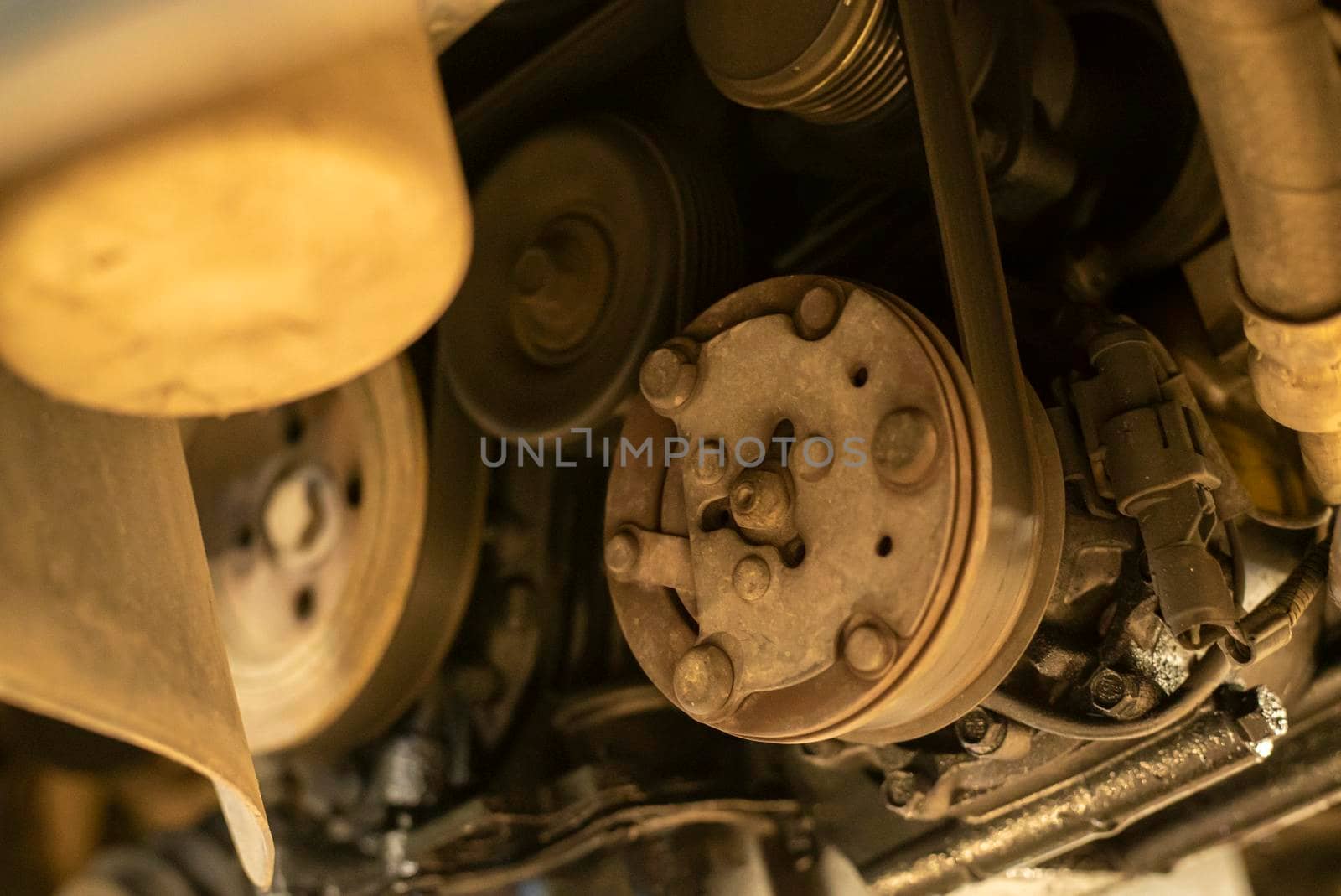 Detail of pulleys and belts on the car engine being repaired