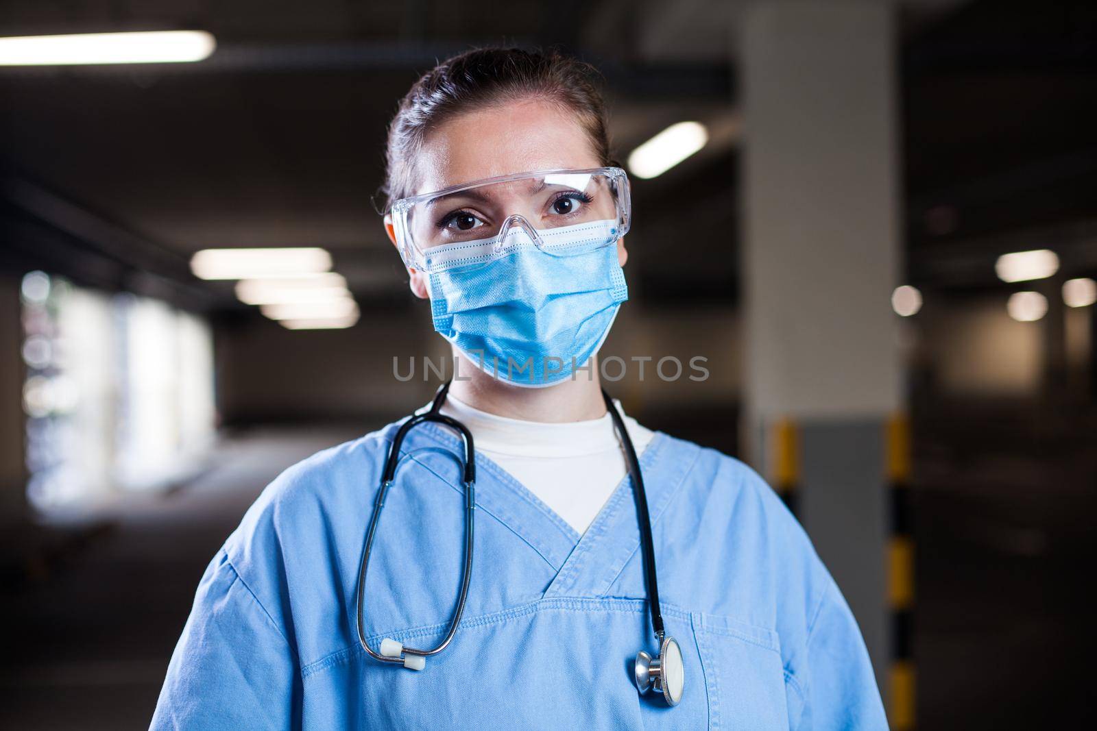 Frontline medical worker working long night shifts in EMS clinic or Coronavirus mobile testing center by Plyushkin