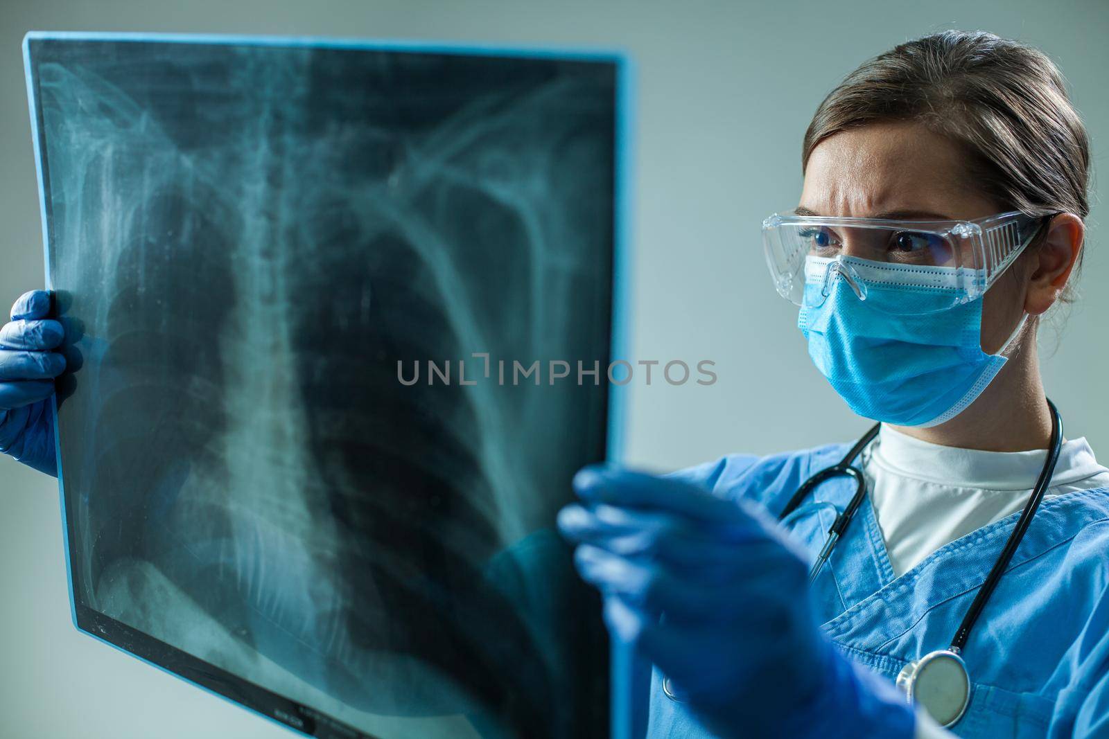 Female GP doctor holding chest x-ray film scan by Plyushkin