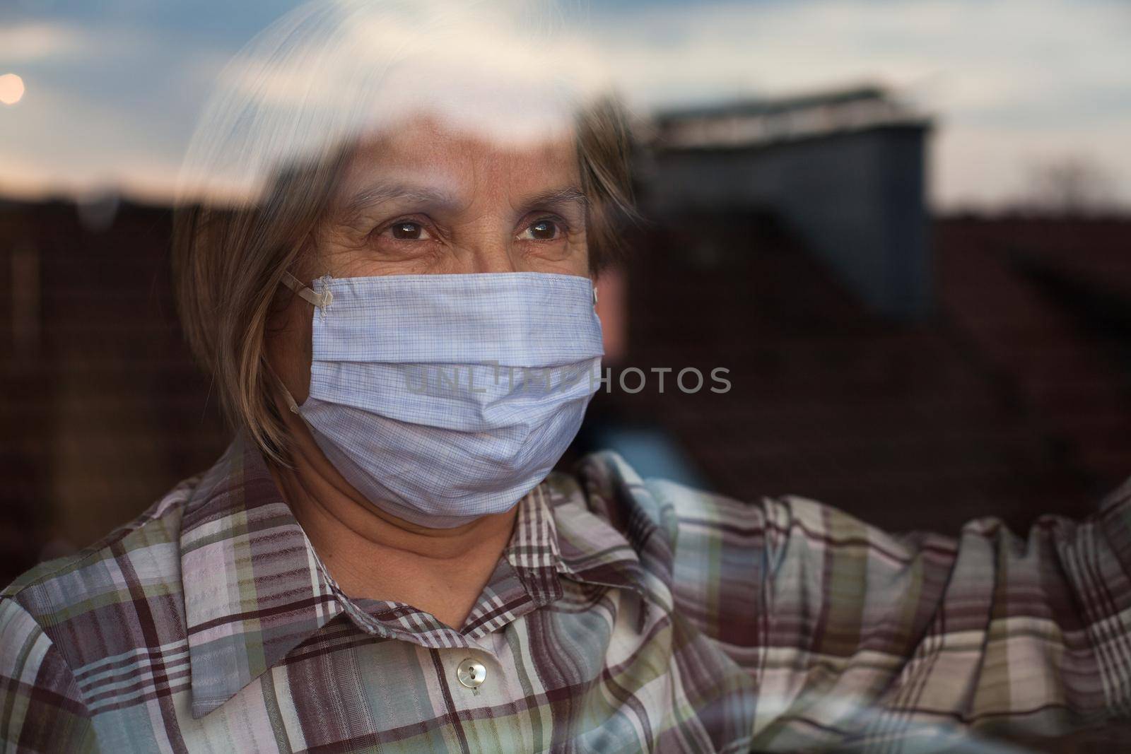 Elderly caucasian woman wearing handmade protective face mask by Plyushkin