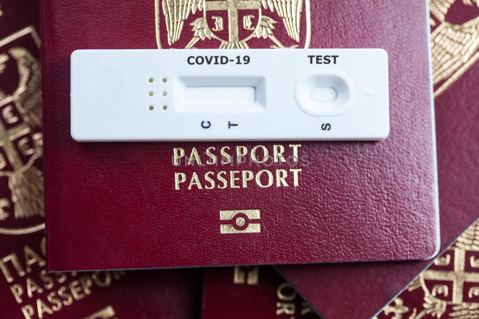 Rapid serology COVID-19 test cassette on red biometric passport,travel in the time of Coronavirus concept,antibody testing upon arrival or departure to if person was infected,proof of convalescence