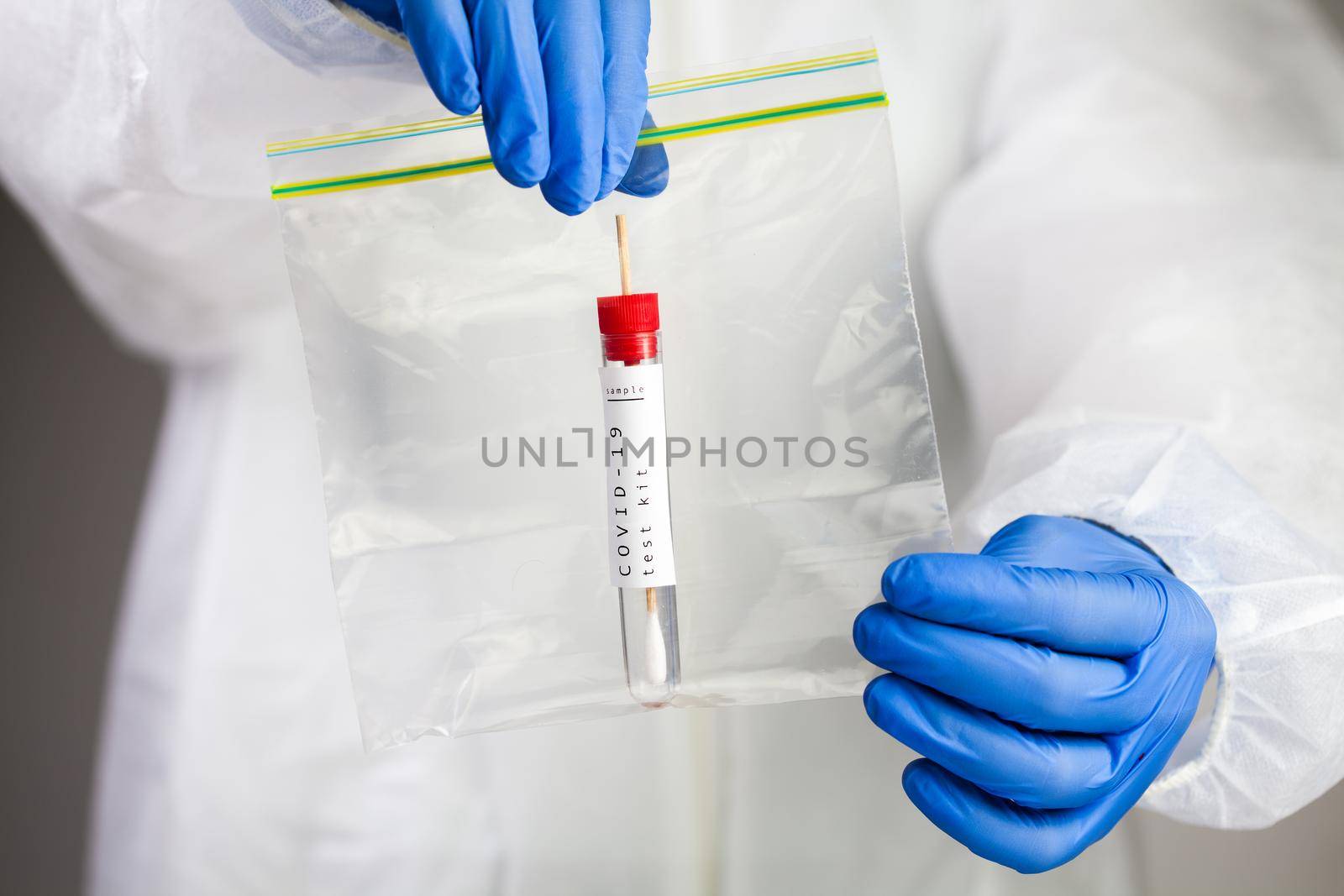 Coronavirus COVID-19 testing,swab collection equipment,sterile vacutainer with swabbing stick,closeup of hands holding a packaging bag containing specimen self collection kit,at home point of care
