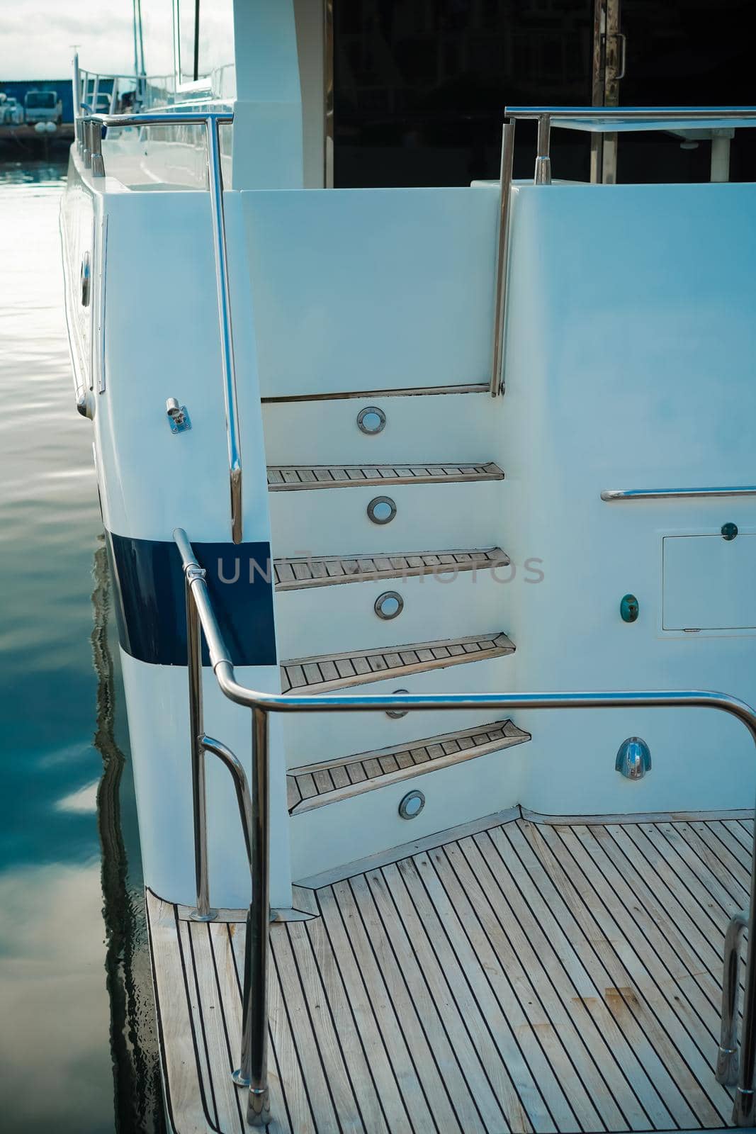 Details of the hull of a white yacht on the background of the water surface