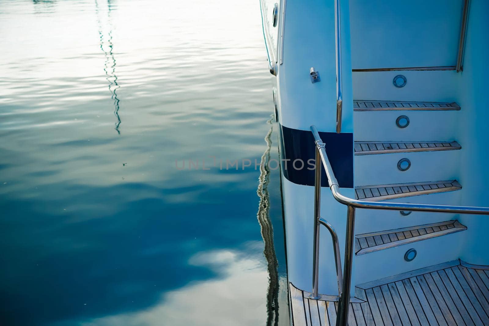 Details of the hull of a white yacht on the background of the water surface
