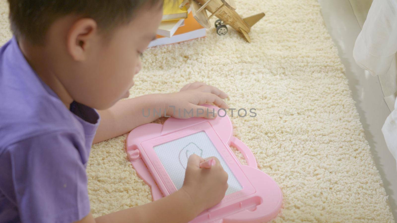 klid little boy preschool writing at the magnetic drawing board by Sorapop